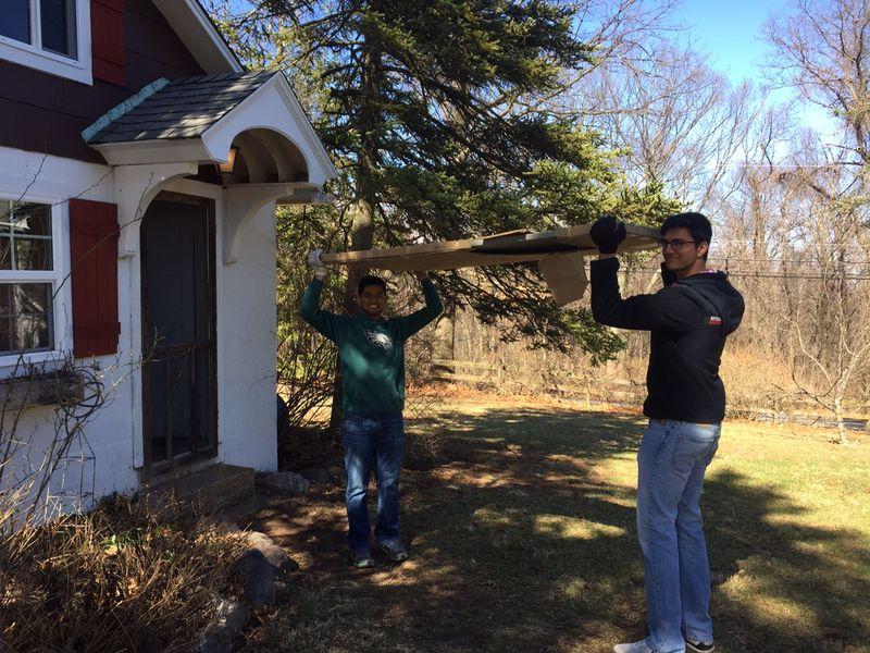 Students moving planks of wood