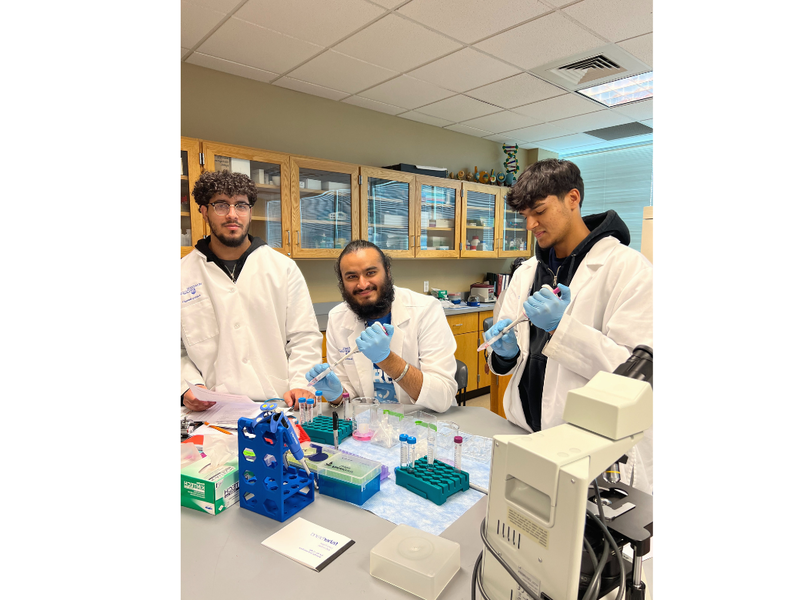 3 male biologists using lab equipment and smiling 