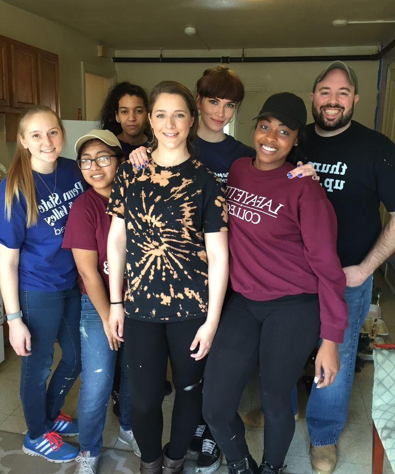 Group of students and staff member posing while volunteering