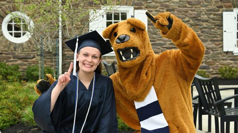 Nittany狮子吉祥物和女毕业生在户外