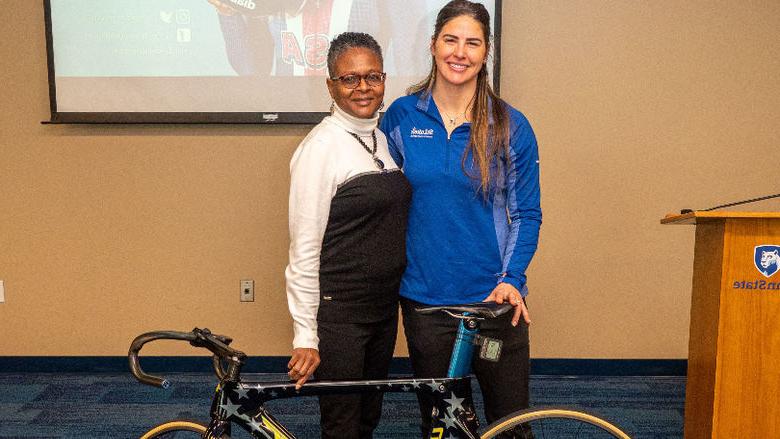 Mandy Marquardt and Tina Richardson stand next to bike. 