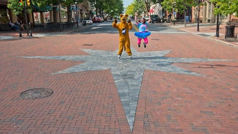Student and Nittany Lion jump for joy in middle of Main Street in Bethlehem, Pennsylvania.